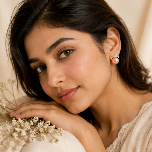 Gold tone CZ bow earrings with peach pearl closeup JeevaFashions