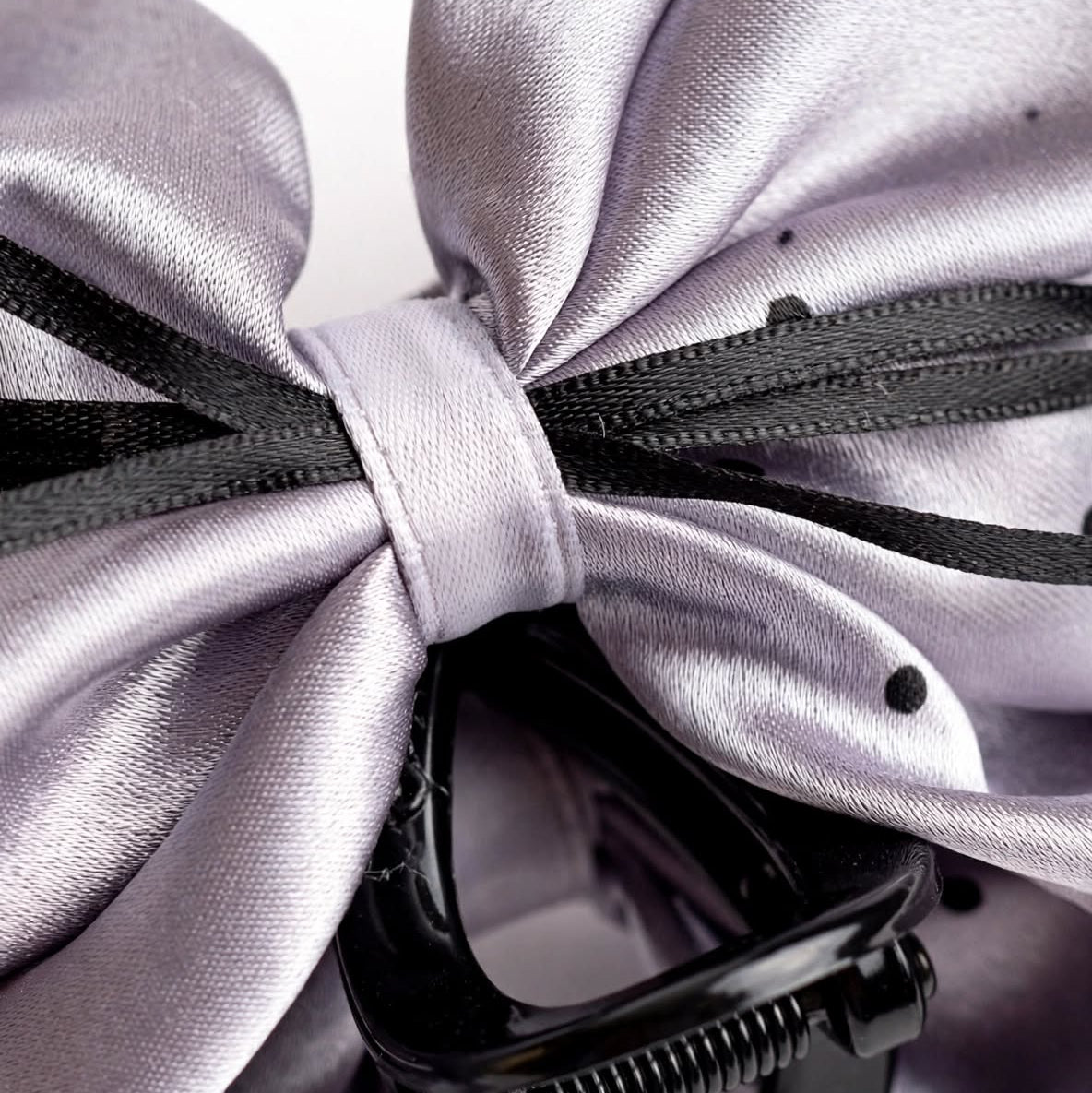 Macro close-up of silver satin bow claw clip polka dot detail