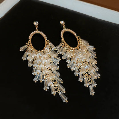 Crystal tassel chandelier earrings in gold tone with rhinestone oval hoop – party wear earrings for Indian women at weddings and festive occasions