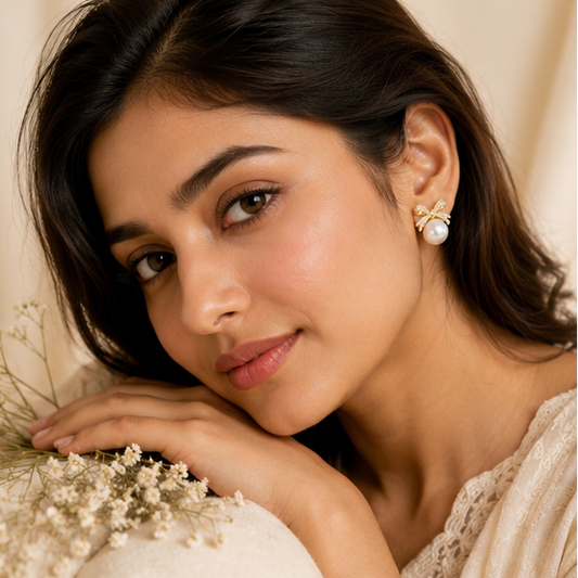 Gold tone CZ bow earrings with pearl drop closeup JeevaFashions