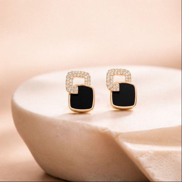 Close-up of geometric gold enamel stud earrings with crystal detailing – minimal Korean earrings for Indian women