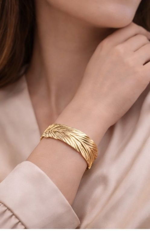 Gold plated feather bracelet on wrist lifestyle shot