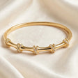 Close-up of pave crystal X knot detail on gold bangle bracelet for women at JeevaFashions