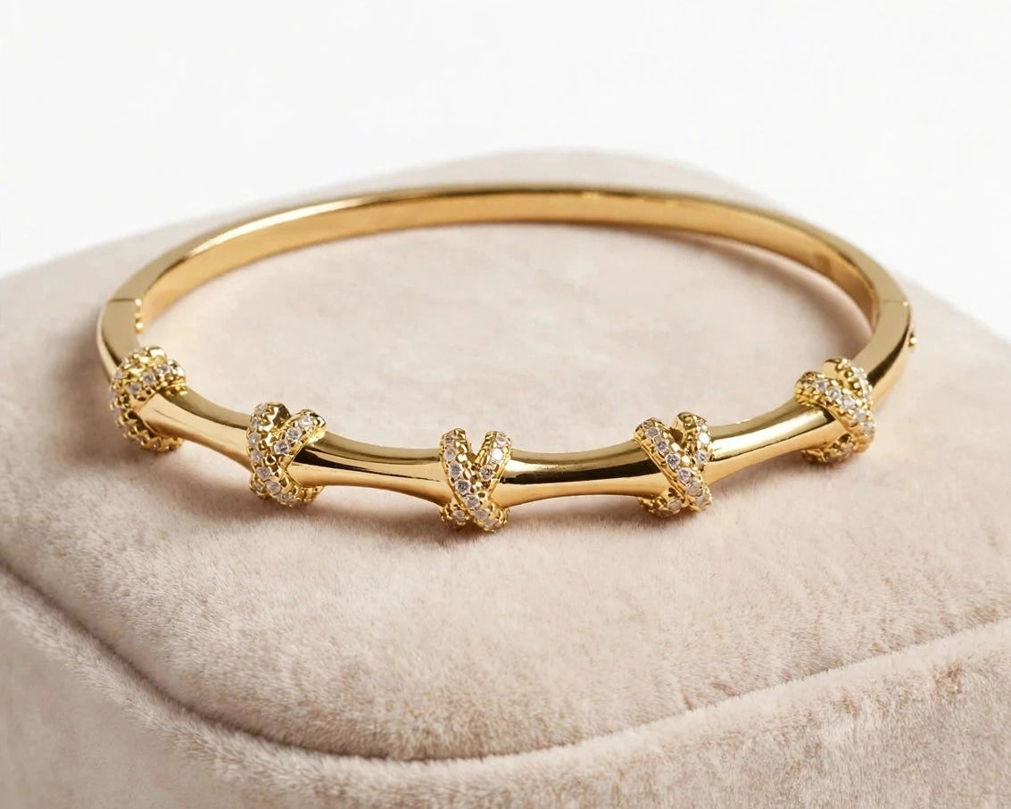 Pave X knot bangle bracelet in gold stainless steel for women at JeevaFashions