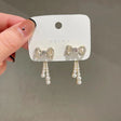 Gold-tone pearl drop earrings with crystal pavé bow and cascading faux pearl fringe for women – bridal and Indian wedding jewellery