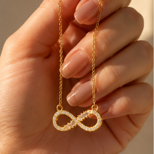 Close-up of gold plated infinity pendant with baguette and round CZ stone setting – anti-tarnish jewellery for women