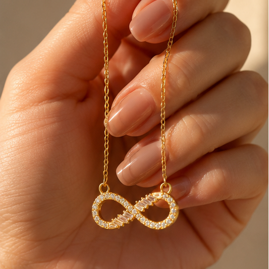 Close-up of gold plated infinity pendant with baguette and round CZ stone setting – anti-tarnish jewellery for women