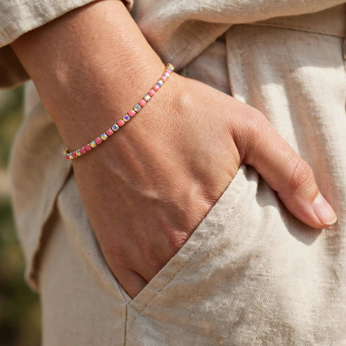 Close-up of pink and iridescent crystal chain detail on gold bangle for women at JeevaFashions