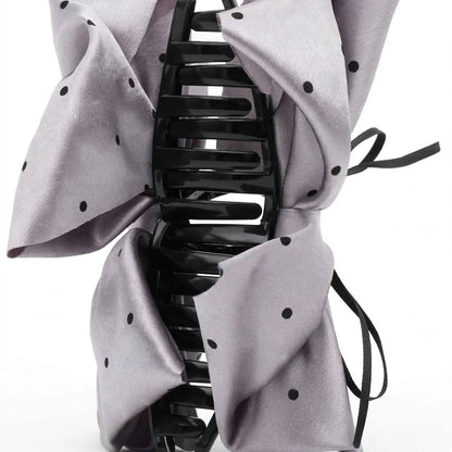 Front view of silver satin polka dot bow claw clip