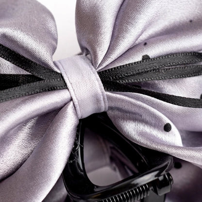Macro close-up of silver satin bow claw clip polka dot detail